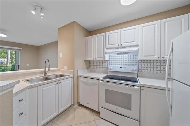 a kitchen with white cabinets appliances and sink