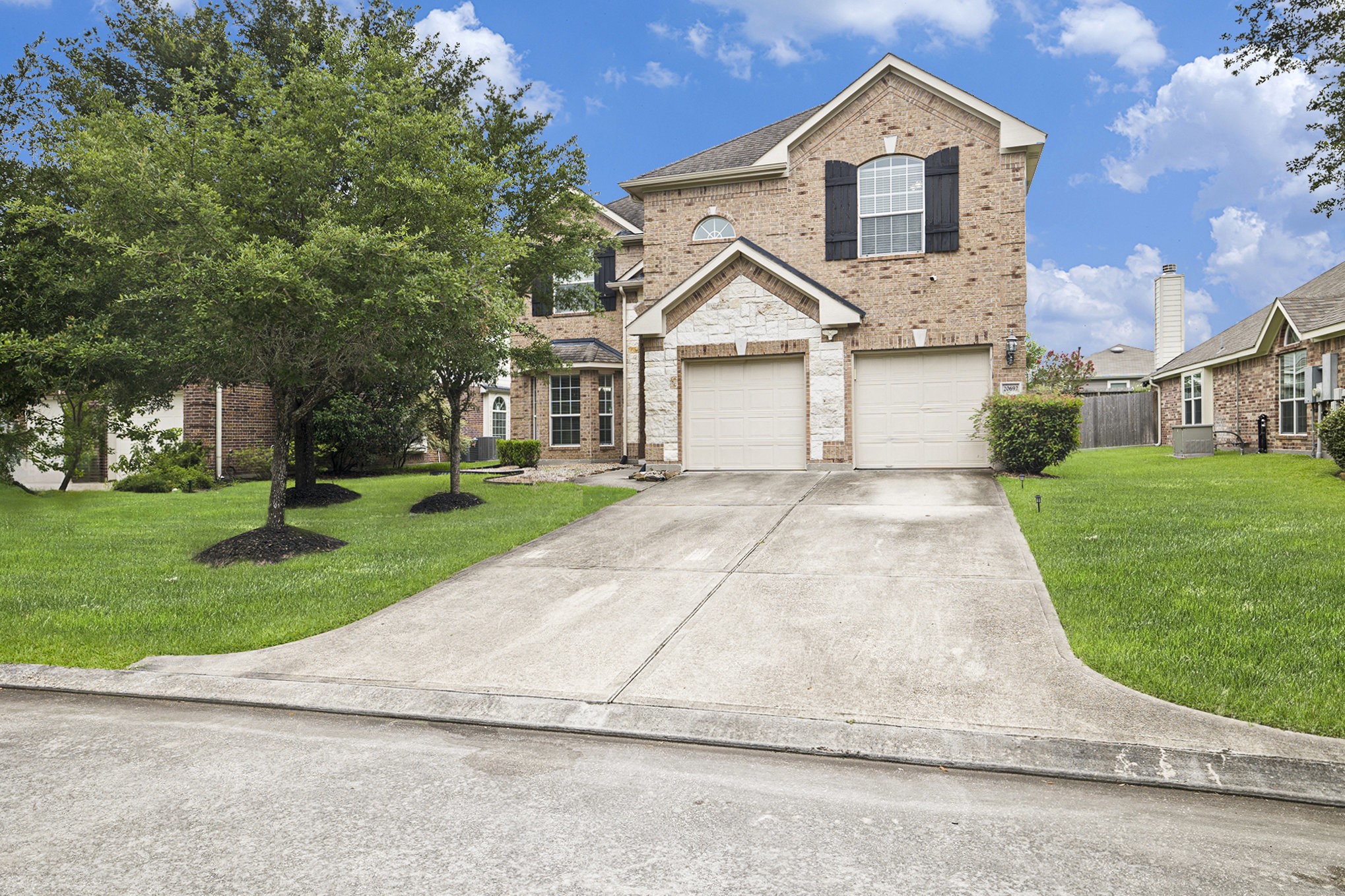 20692 Oakhurst Meadows Drive Porter, TX 77365 - Photo 2 of 37 a view of a white house next to a yard with big trees