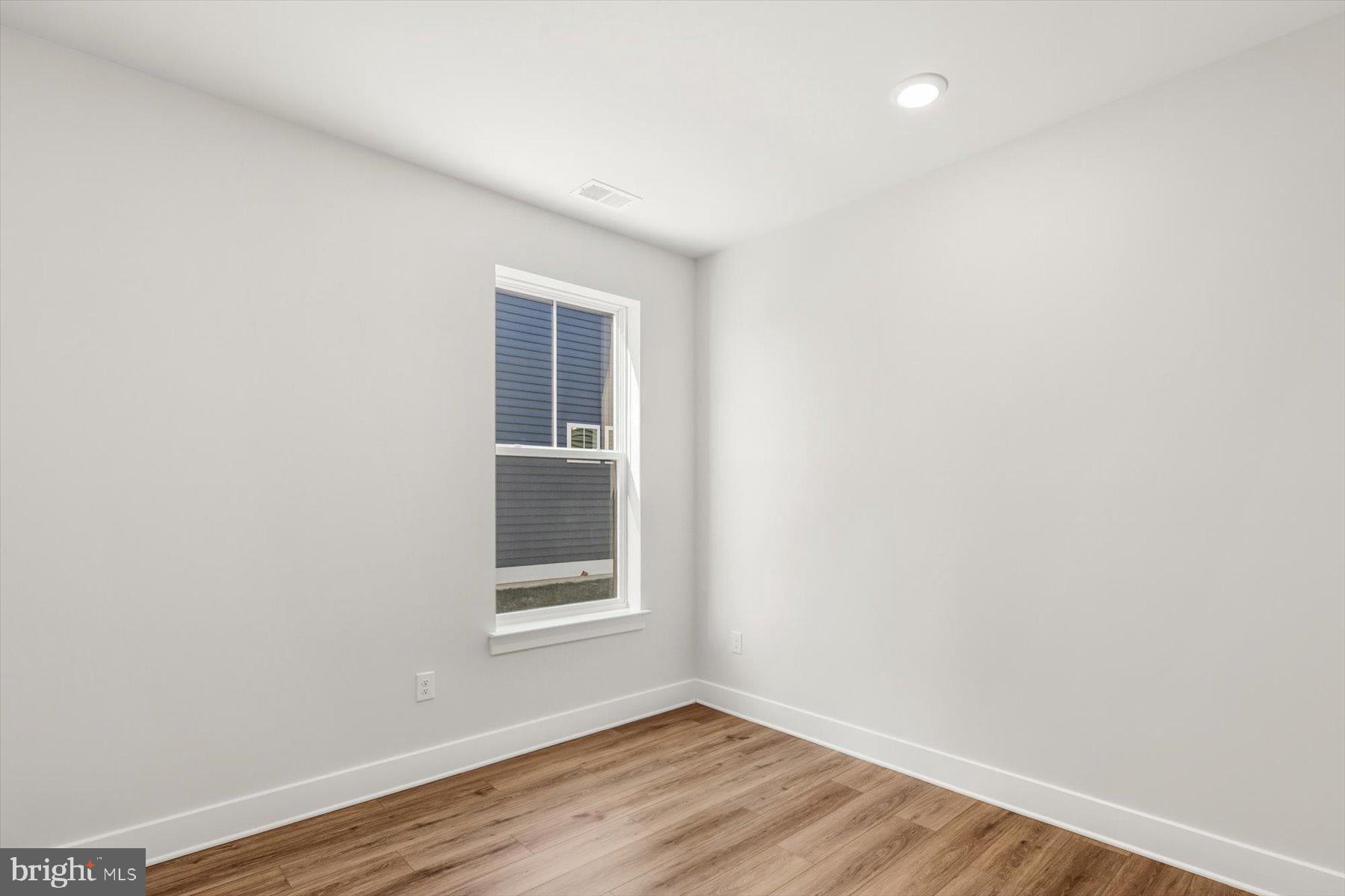 104 Sunbeam Way Milton, DE 19968 - Photo 39 of 56 a view of an empty room with wooden floor and a window
