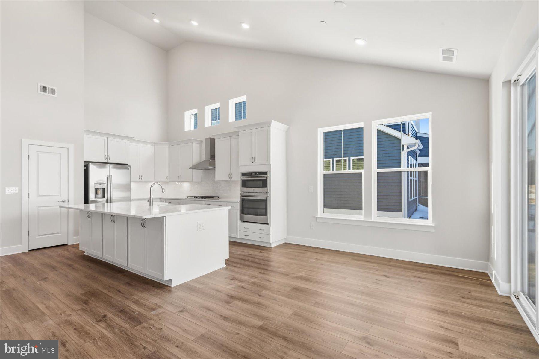 104 Sunbeam Way Milton, DE 19968 - Photo 9 of 56 a kitchen with white cabinets and wooden floor