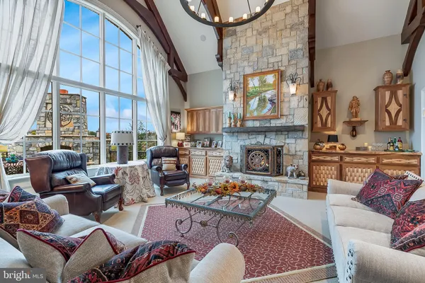 a view of a dining room with furniture wooden floor fireplace and a chandelier