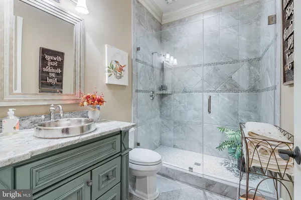 a bathroom with a granite countertop sink a toilet and a mirror
