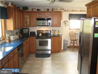 27 Harvard Road Audubon, NJ 08106 - Photo 4 of 12 a kitchen with stainless steel appliances granite countertop a refrigerator a stove top oven a sink and dishwasher