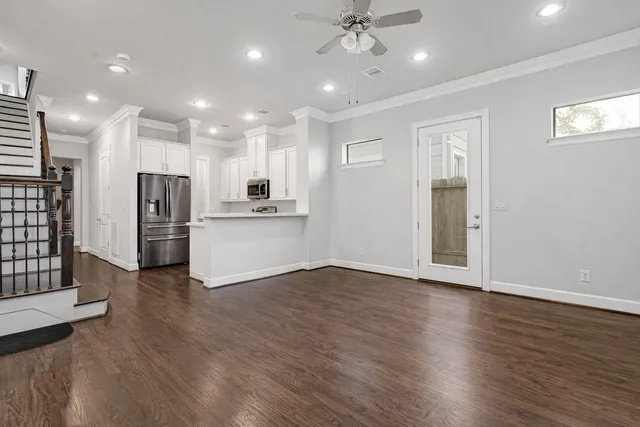 a view of a kitchen with refrigerator and wooden floor