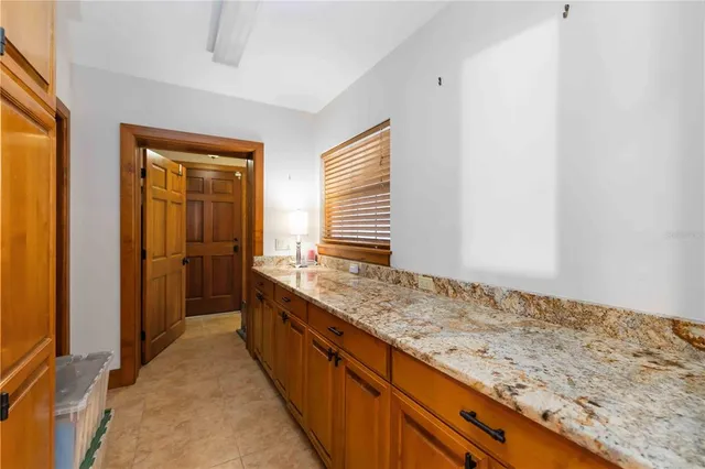 a bathroom with a granite countertop sink and a wooden floor