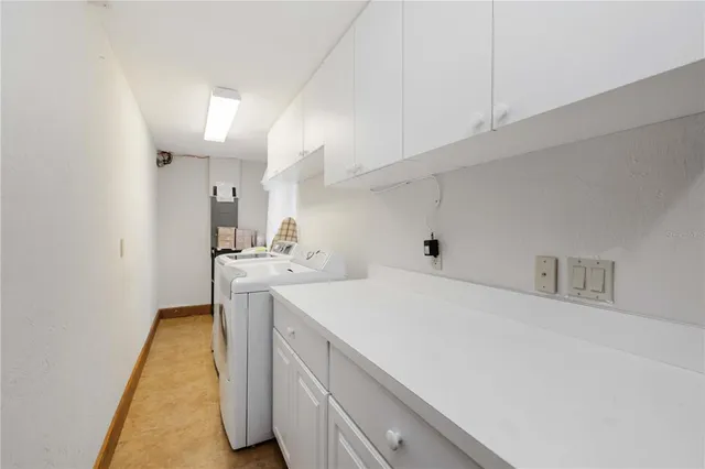a utility room with cabinets washer and dryer