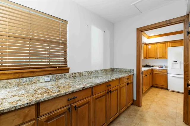a kitchen with granite countertop sink and cabinets