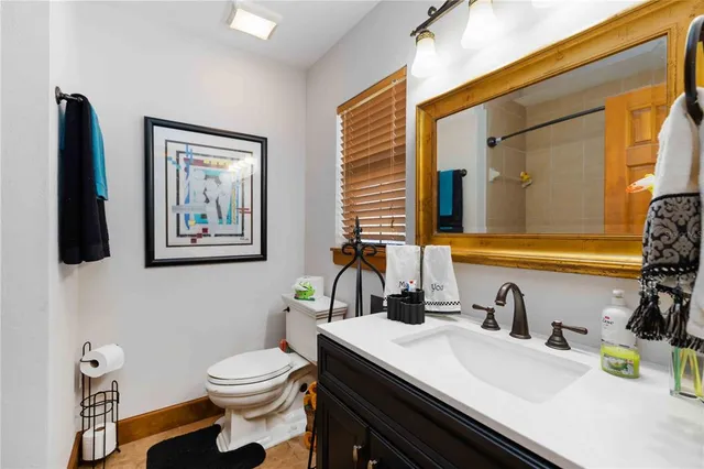 a bathroom with a sink a toilet and a mirror