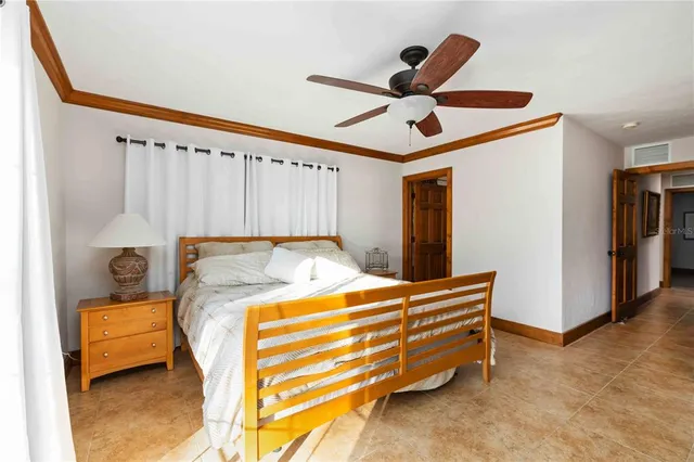 a bedroom with a bed and a ceiling fan