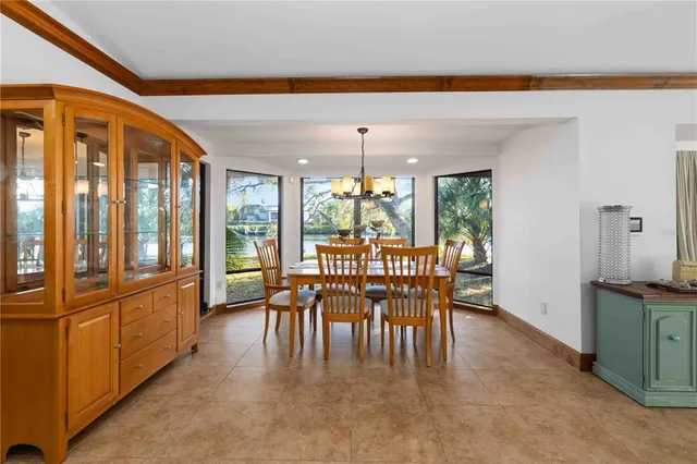 a dining room with furniture and a floor to ceiling window