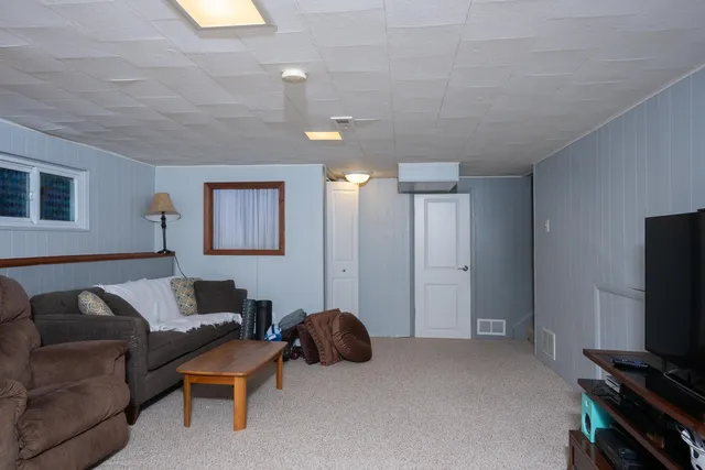 a living room with furniture a flat screen tv and a window