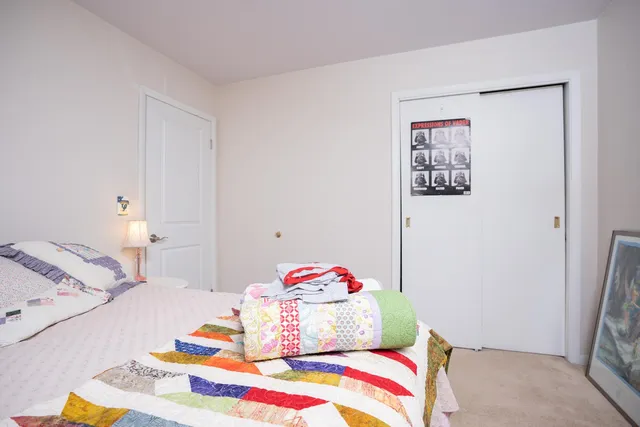 a bedroom with a bed and painting on the wall