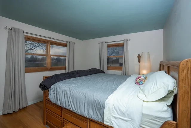 a bedroom with a bed and wooden floor