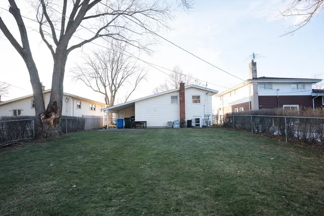 a view of a yard with a house and a large tree