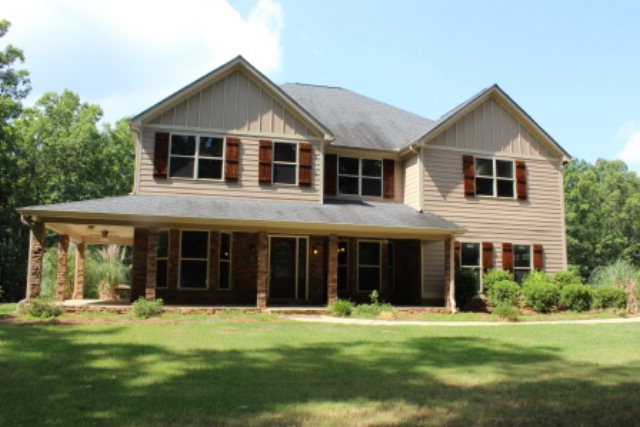 a front view of a house with a yard and trees