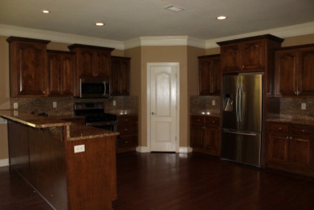 163 Gregory Road Forsyth, GA 31029 - Photo 8 of 20 a kitchen with a refrigerator and a stove top oven