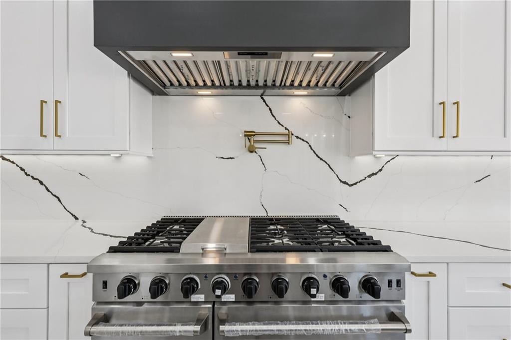1556 Ewing Chapel Road Dacula, GA 30019 - Photo 20 of 67 a stove sitting inside of a kitchen with white cabinets