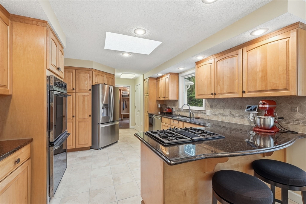 47 Academy Drive Longmeadow, MA 01106 - Photo 17 of 42 a kitchen with stainless steel appliances granite countertop a stove refrigerator sink and cabinets