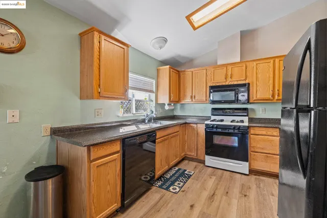 a kitchen with stainless steel appliances granite countertop a stove refrigerator sink and microwave