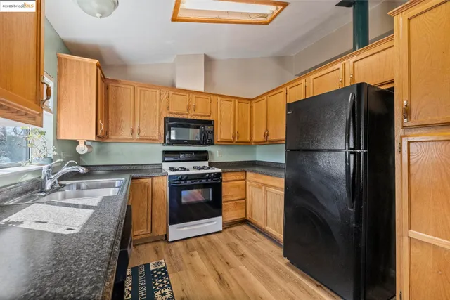 a kitchen with granite countertop a refrigerator stove and microwave