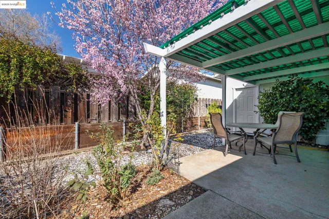 a view of a patio with table and chairs with wooden floor and fence