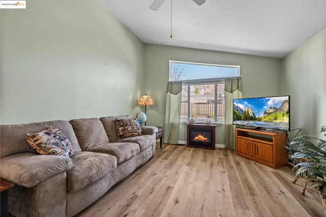 a living room with furniture flat screen tv and wooden floor