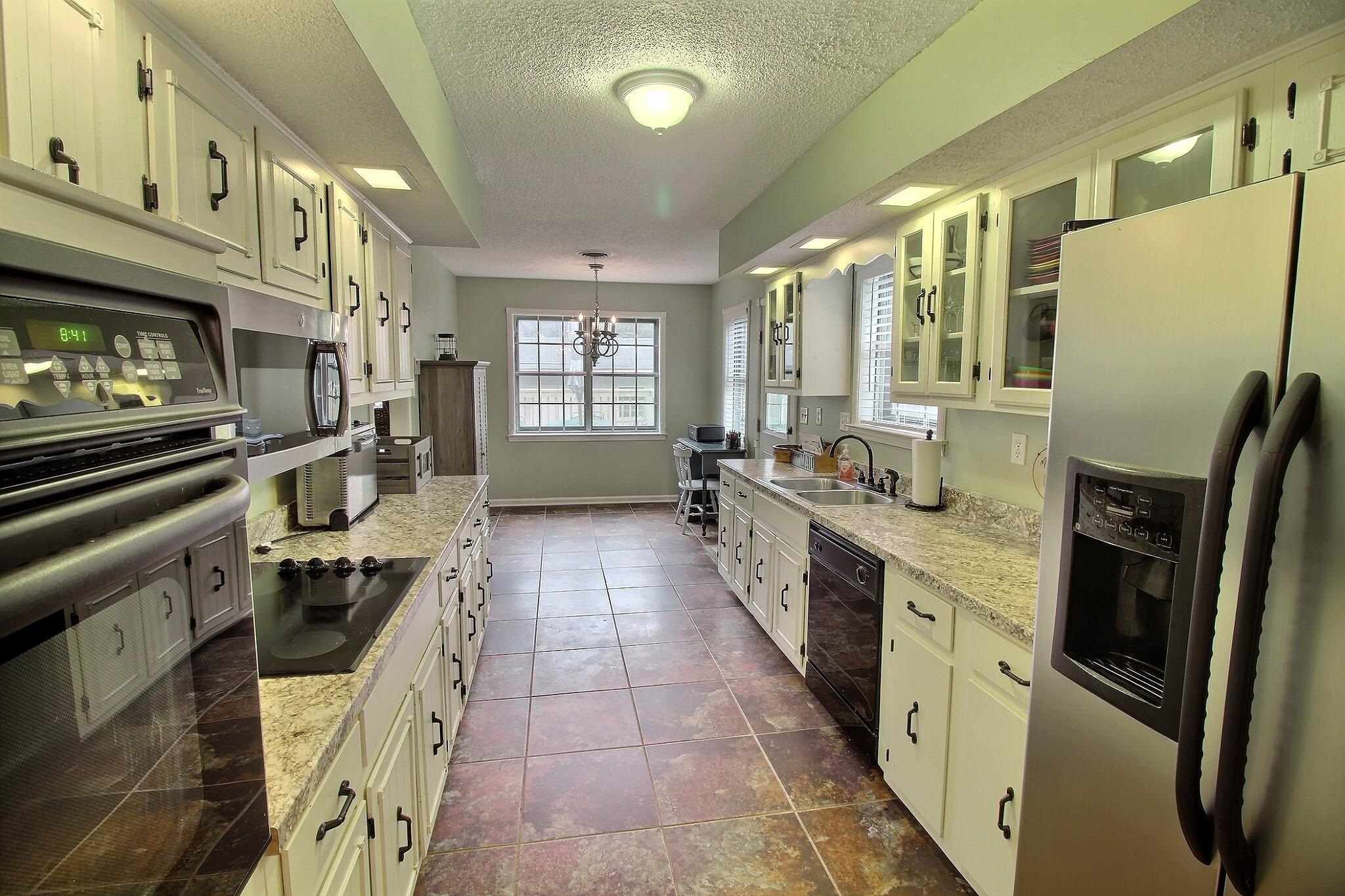 348 Rutledge Street Collierville, TN 38017 - Photo 9 of 19 a kitchen with stainless steel appliances granite countertop a refrigerator a stove a sink dishwasher and white cabinets with wooden floor