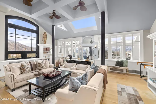 a dining room with furniture a chandelier and wooden floor