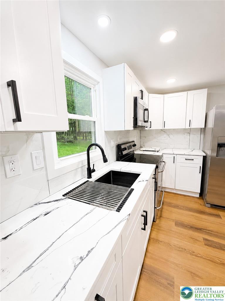 182 Mountain Road Albrightsville, PA 18210 - Photo 16 of 17 Sleek, bright kitchen with quartz countertops and modern black fixtures.