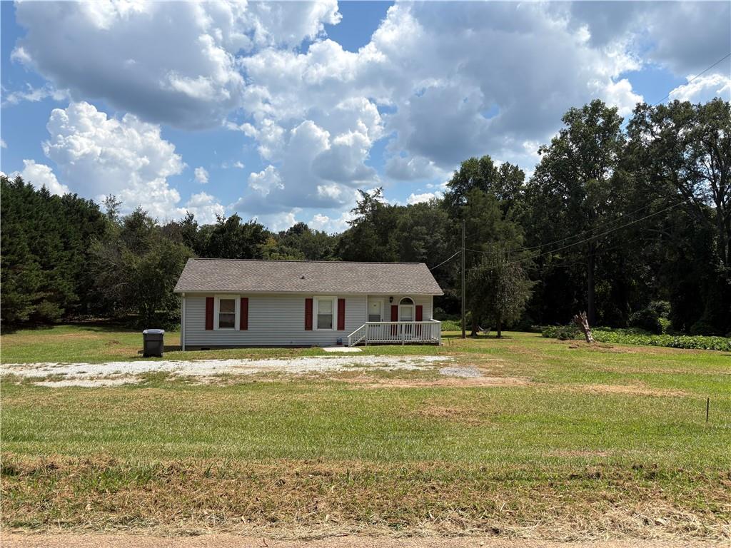 a front view of a house with a yard and trees