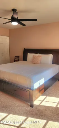 a bedroom with a bed and a lamp on the dresser
