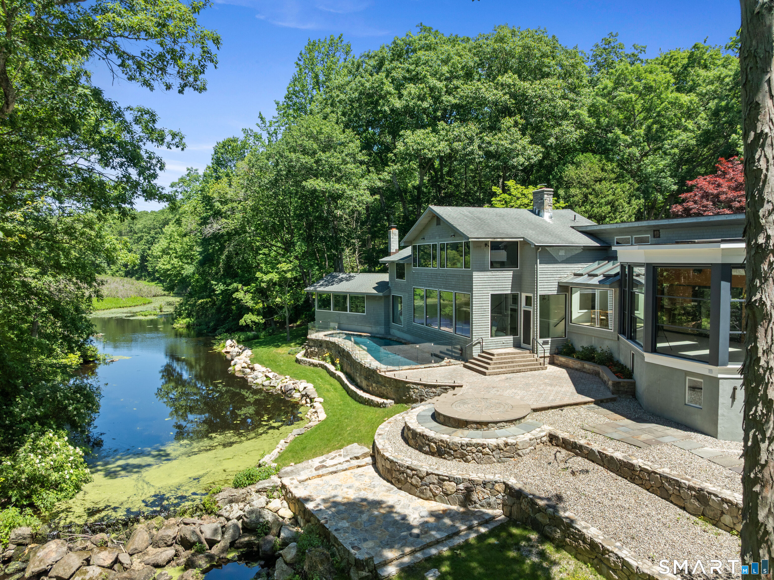 22 Pent Road Weston, CT 06883 - Photo 3 of 18 a view of a house with backyard sitting area and swimming pool