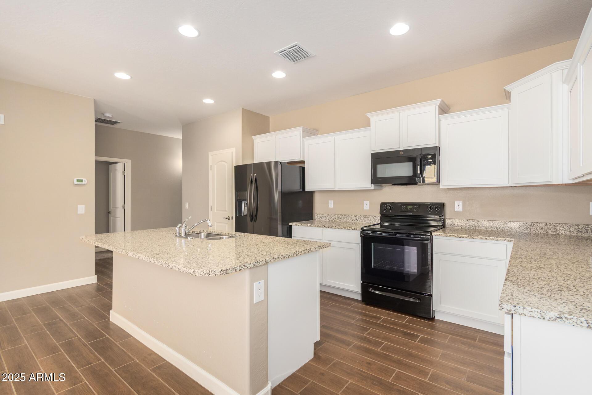 23882 West Ripple Road Buckeye, AZ 85326 - Photo 11 of 26 a kitchen with stainless steel appliances granite countertop a sink stove and refrigerator