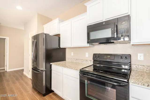 a kitchen with stainless steel appliances granite countertop a sink stove and cabinets