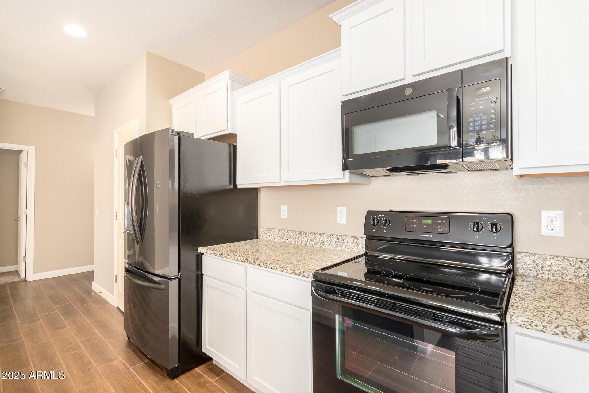 23882 West Ripple Road Buckeye, AZ 85326 - Photo 12 of 26 a kitchen with a refrigerator stove and microwave