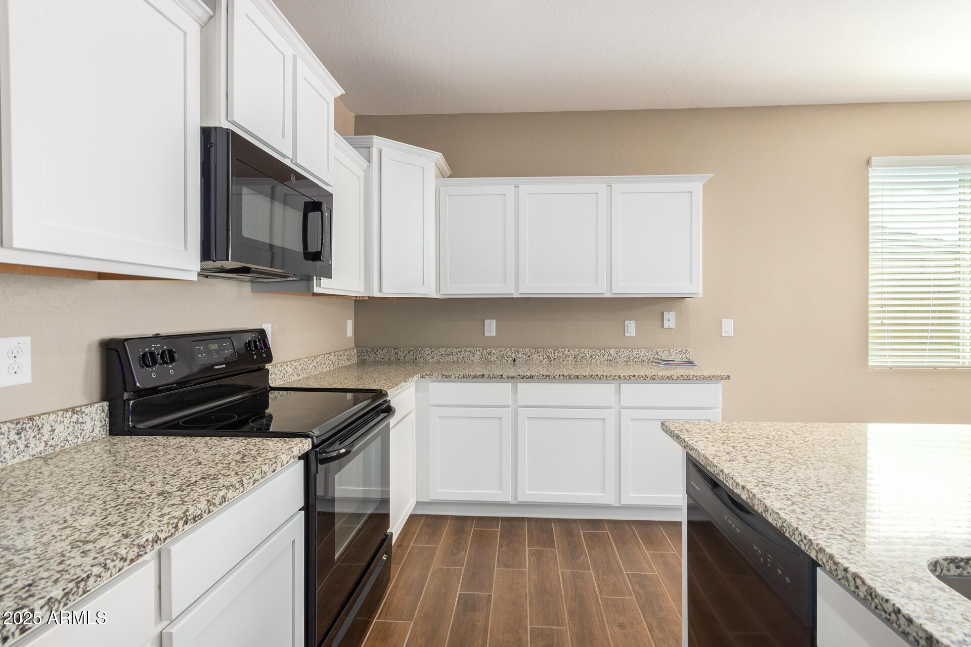 23882 West Ripple Road Buckeye, AZ 85326 - Photo 13 of 26 a kitchen with stainless steel appliances granite countertop a sink stove and cabinets