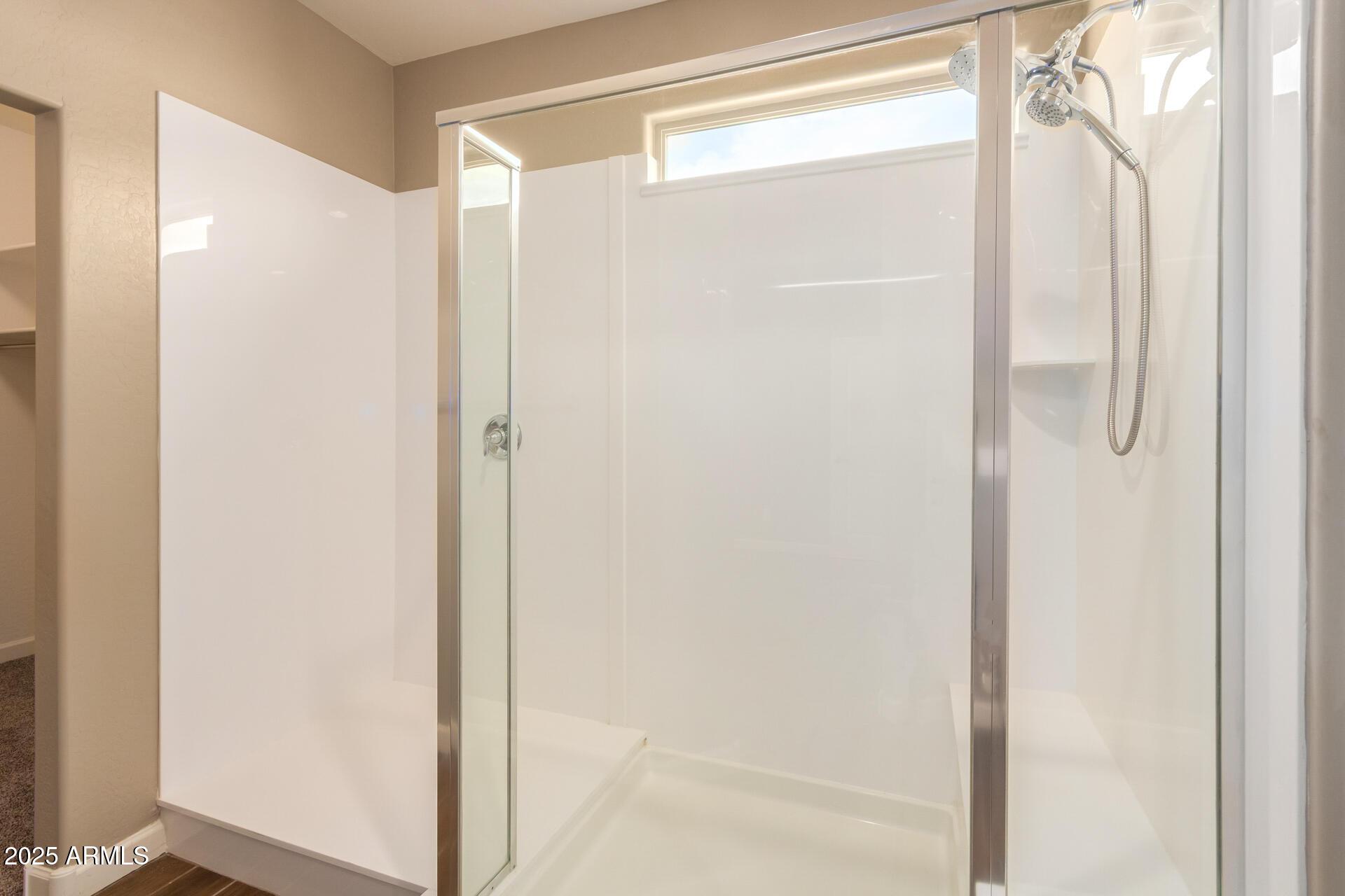 23882 West Ripple Road Buckeye, AZ 85326 - Photo 19 of 26 a bathroom with a glass shower door