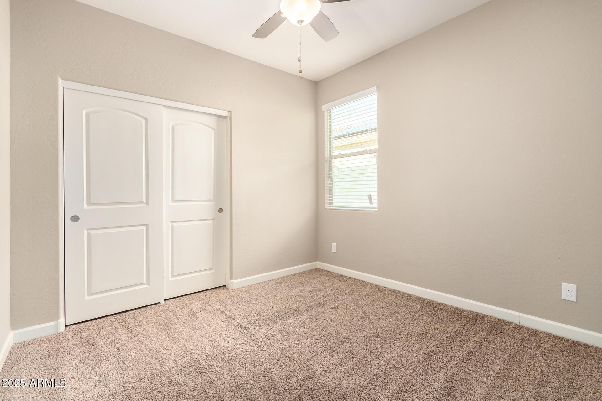 23882 West Ripple Road Buckeye, AZ 85326 - Photo 23 of 26 an empty room with a window and a ceiling fan
