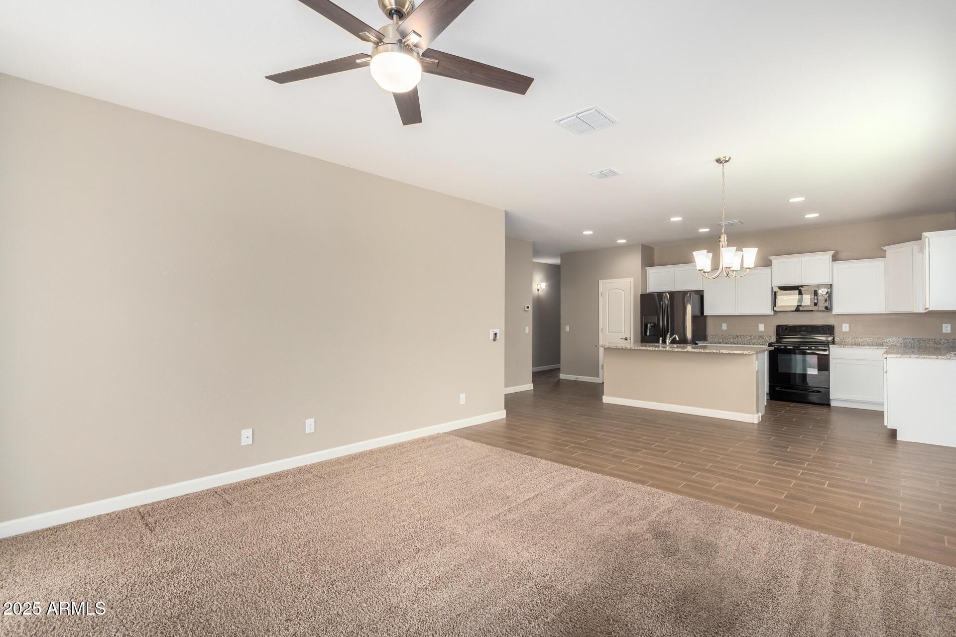 23882 West Ripple Road Buckeye, AZ 85326 - Photo 6 of 26 a view of a kitchen with a sink and a stove top oven