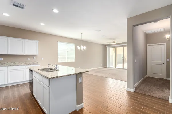 a kitchen with kitchen island granite countertop a sink stove and refrigerator