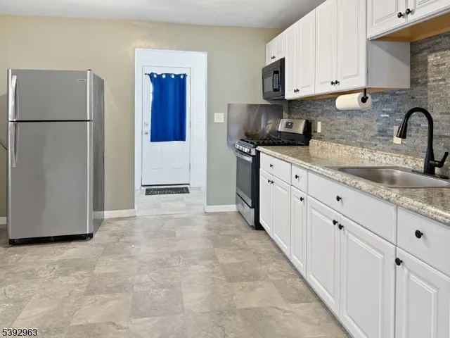 a kitchen with stainless steel appliances granite countertop a refrigerator and a stove