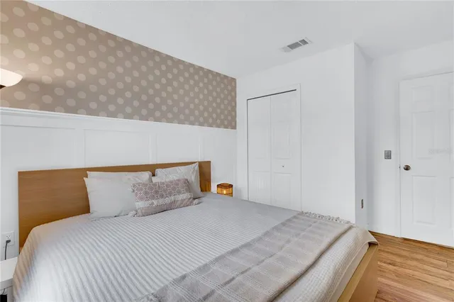 a bedroom with a bed and wooden floor