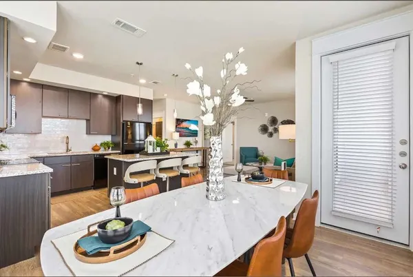 a room with stainless steel appliances kitchen island a table and chairs in it