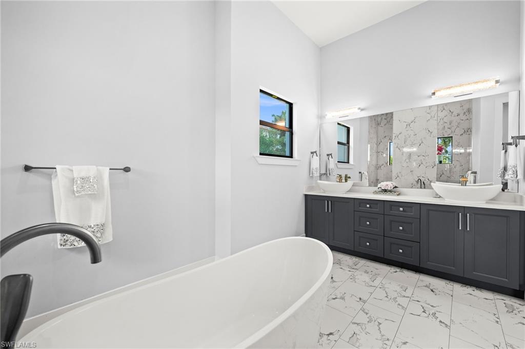 388 Pine Avenue Naples, FL 34108 - Photo 22 of 34 a bathroom with a sink a bathtub and a mirror