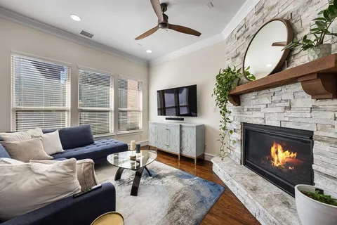 a living room with furniture a flat screen tv and a fireplace