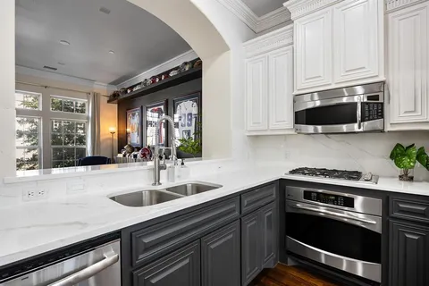 a kitchen with stainless steel appliances granite countertop a sink a stove and microwave