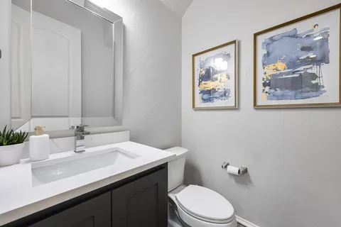 a bathroom with a toilet a sink and mirror