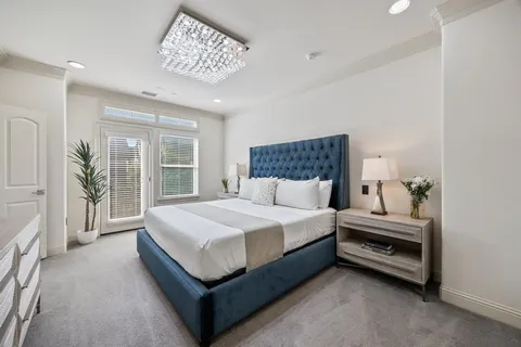 a spacious bedroom with a large bed and a chandelier