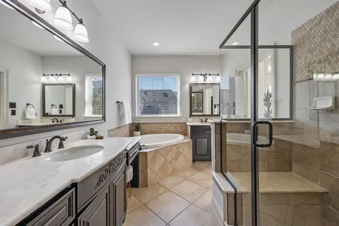 a bathroom with a granite countertop sink mirror and bathtub