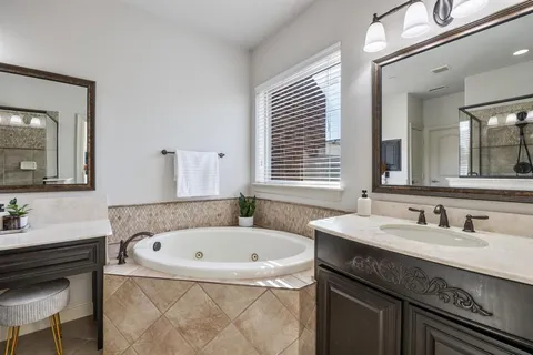 a bathroom with a tub sink and mirror